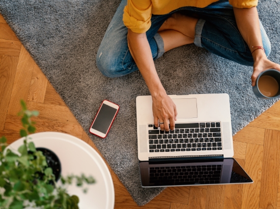 person sitting on floor using computer